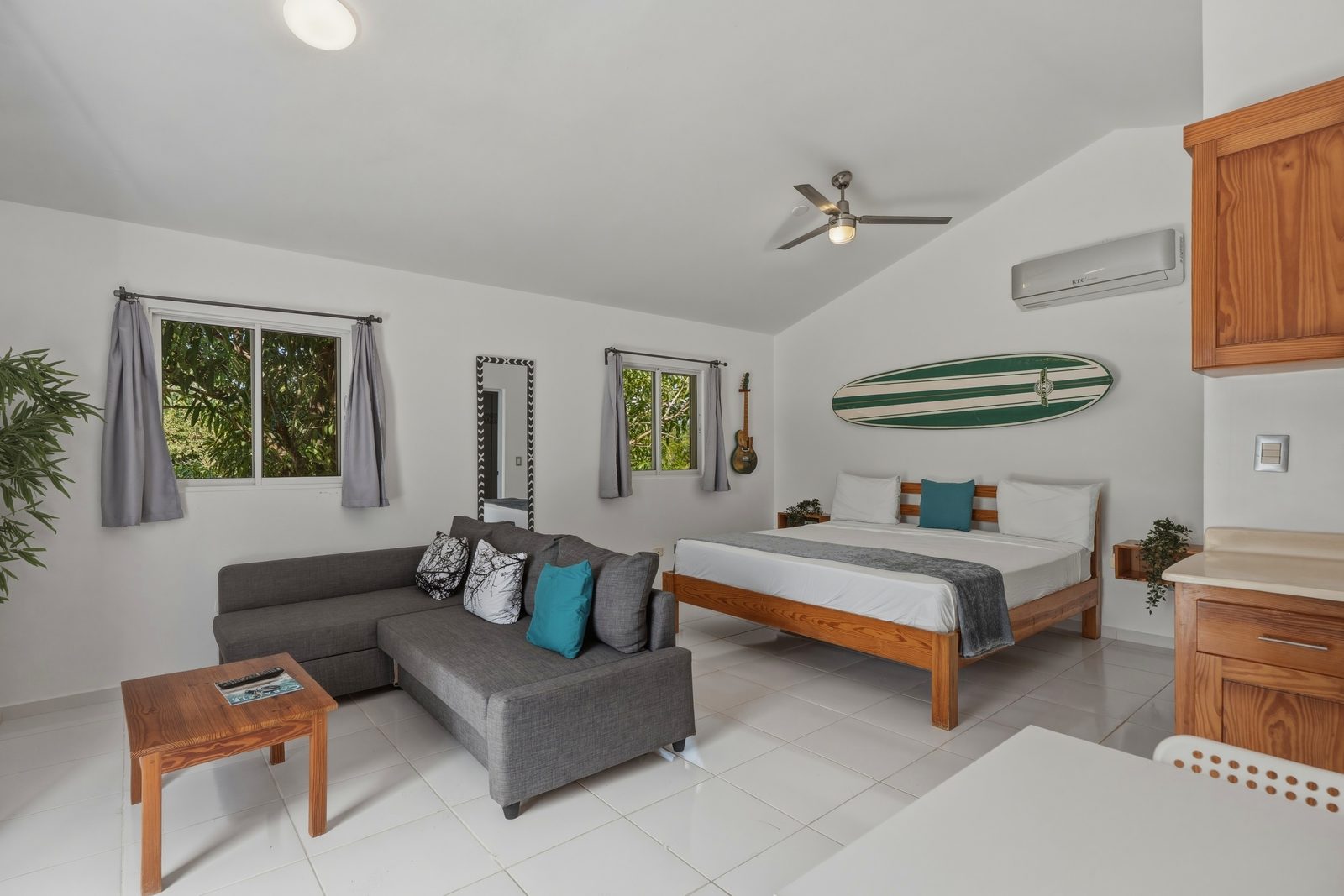 Studio with green surfboard and sectional sofa / Estudio con tabla de surf verde y sofá seccional