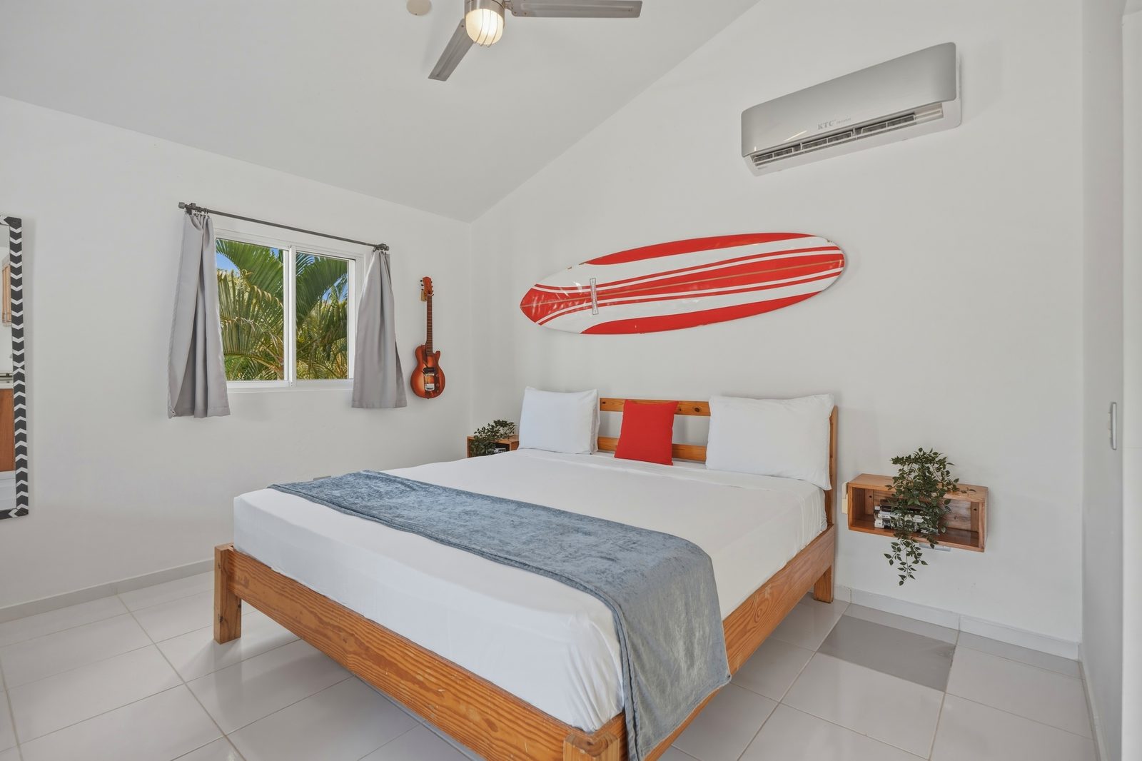 Studio bedroom with orange surfboard / Habitación de estudio con tabla de surf naranja