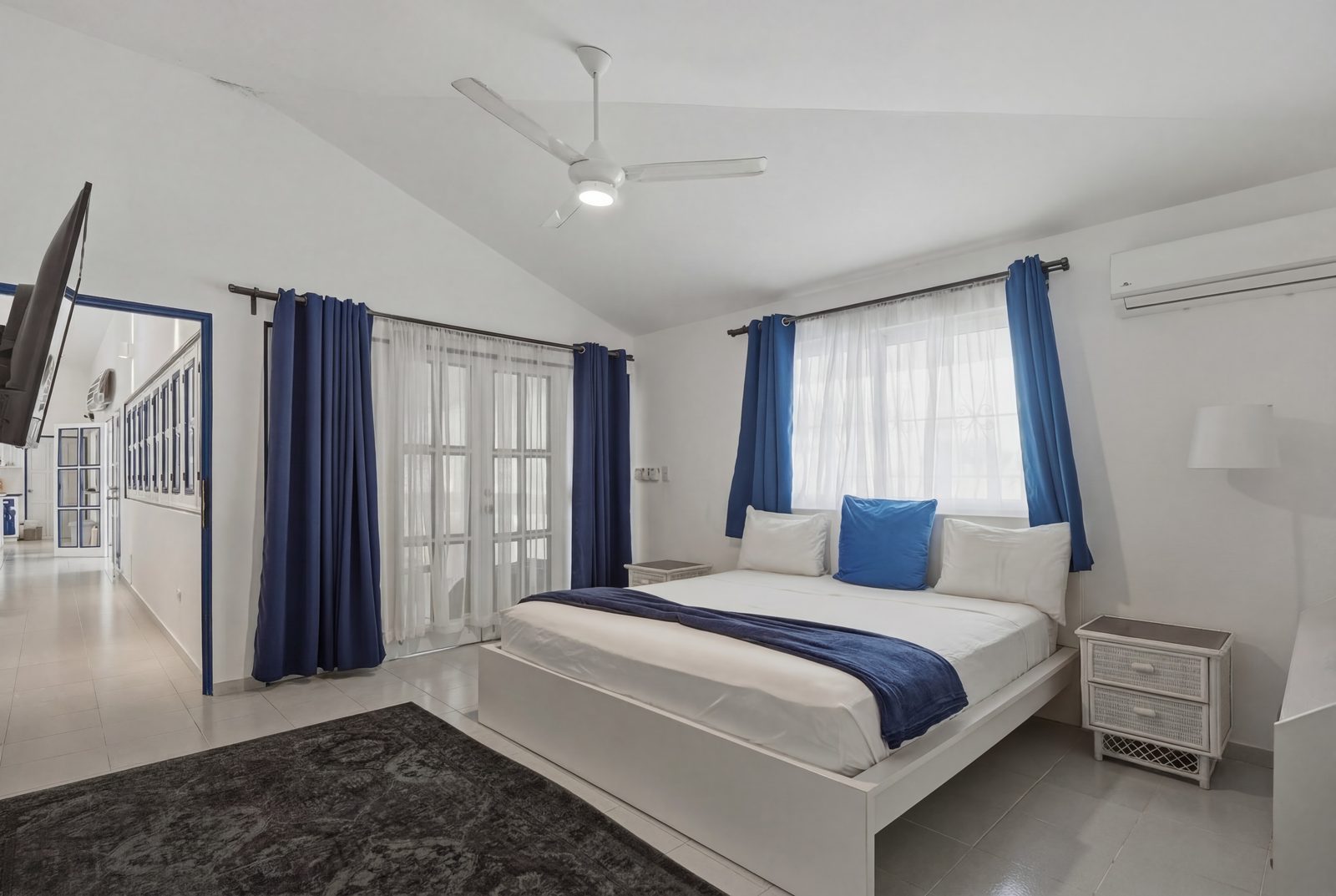 Paradise Point bedroom with navy curtains and French doors / Habitación de Paradise Point con cortinas azul marino y puertas francesas
