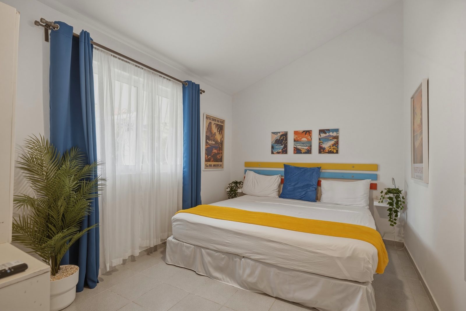 Paradise Point bedroom with yellow throw / Habitación de Paradise Point con manta amarilla